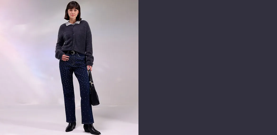 Dunkle Jacke, Jeans mit Strass und passende Tasche.