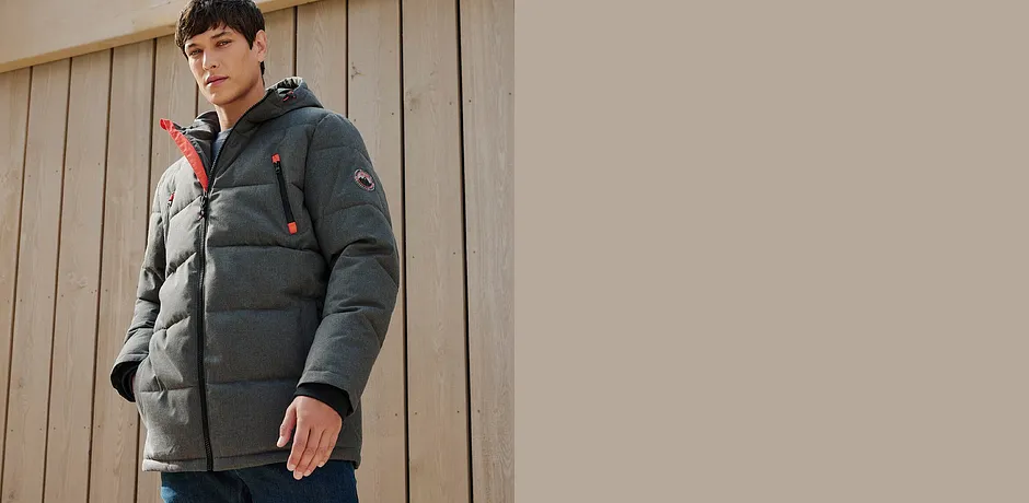 Warme graue Winterjacke mit Kapuze, kombiniert mit Jeans.