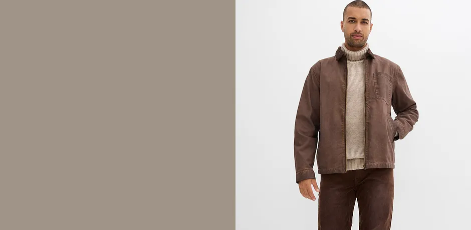 Braune Lederjacke, beiger Rollkragenpullover und passende Hose.