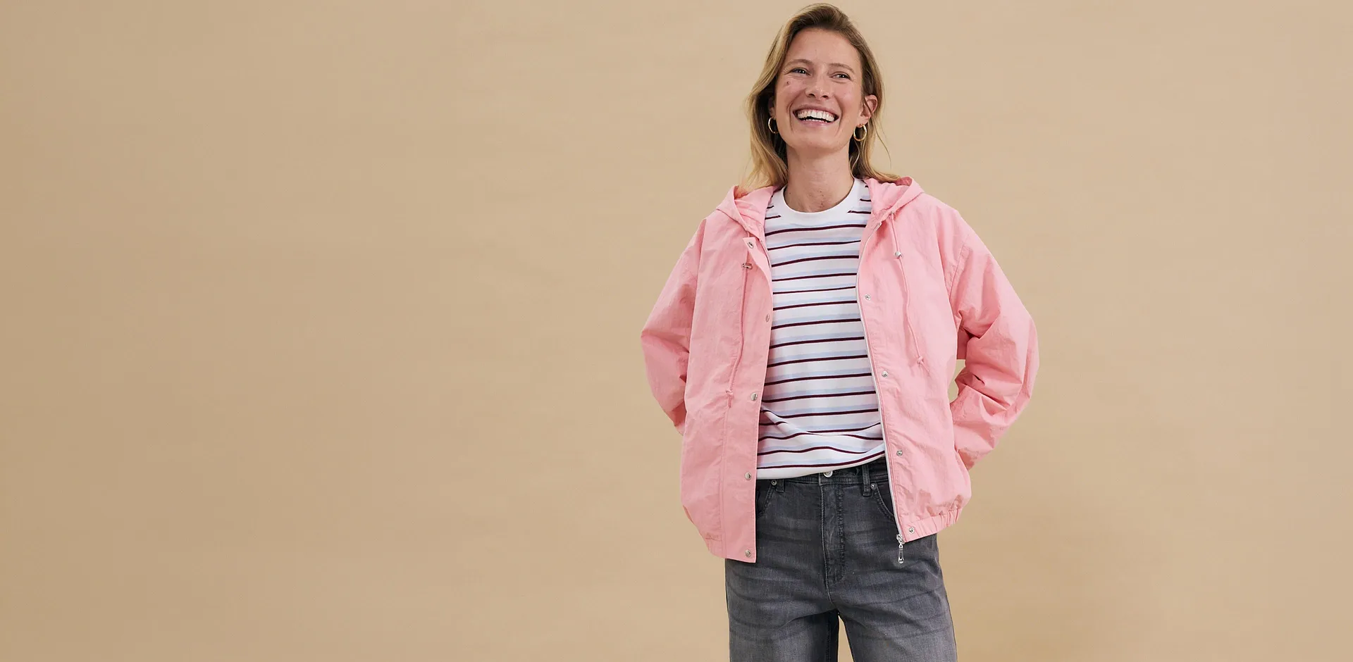 Rosa Jacke über gestreiftem Shirt, kombiniert mit grauer Jeans - lässiger Freizeitlook.