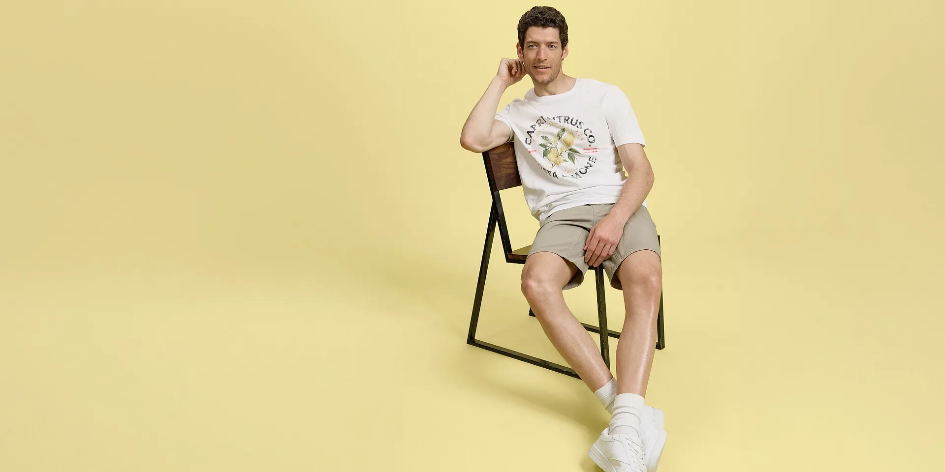 Sommerlooks mit beigen Shorts, weißem T-Shirt und bequemen Sneakers .