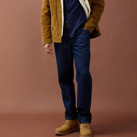 Blaue Jeans, senfgelbe Cordjacke und robuste beige Stiefel.