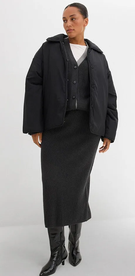 Veste matelassée, jupe longue et bottes en cuir. Haut blanc basique en dessous.