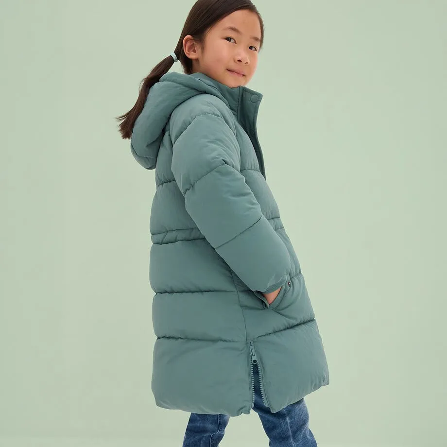 Mädchen in langer, mintgrüner Pufferjacke.