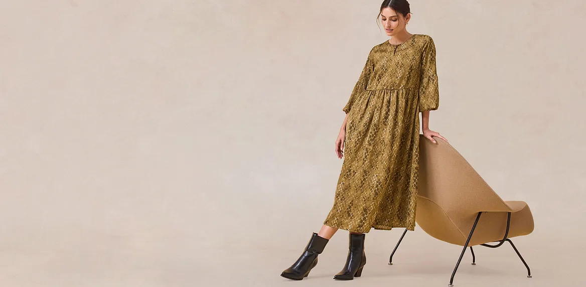 Elegantes grünes Kleid mit langen Ärmeln.