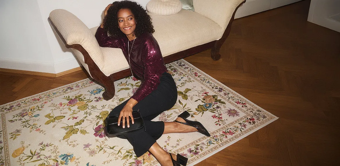 Elegante Langarmshirt in Burgunderrot über dunkler Jeans.