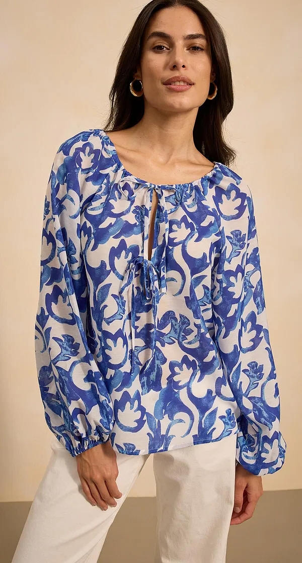 Luftige Bluse mit blau-weißem Blumenmuster und langen Ärmeln.