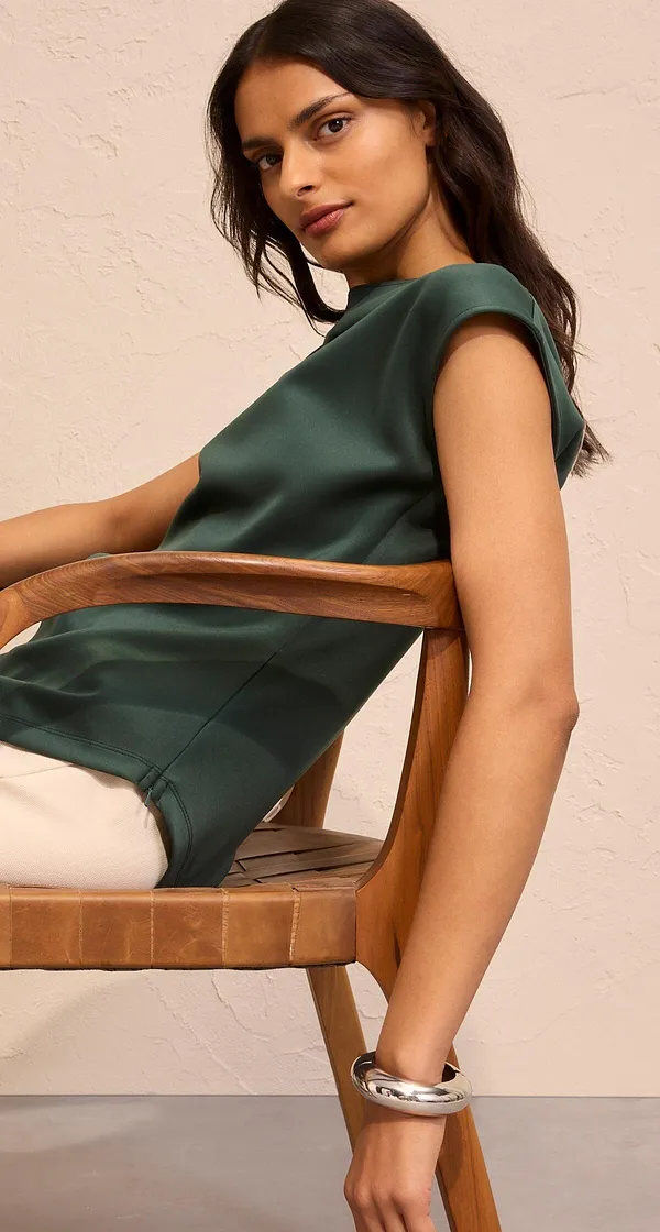 Elegantes dunkelgrünes Shirt kombiniert mit heller Hose.