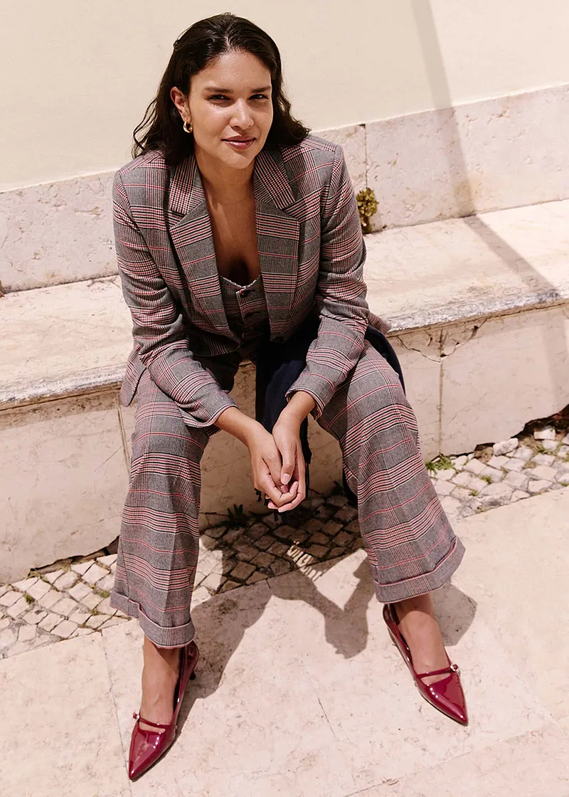 Karierter Blazer und passende Hose kombiniert mit roten Schuhen.