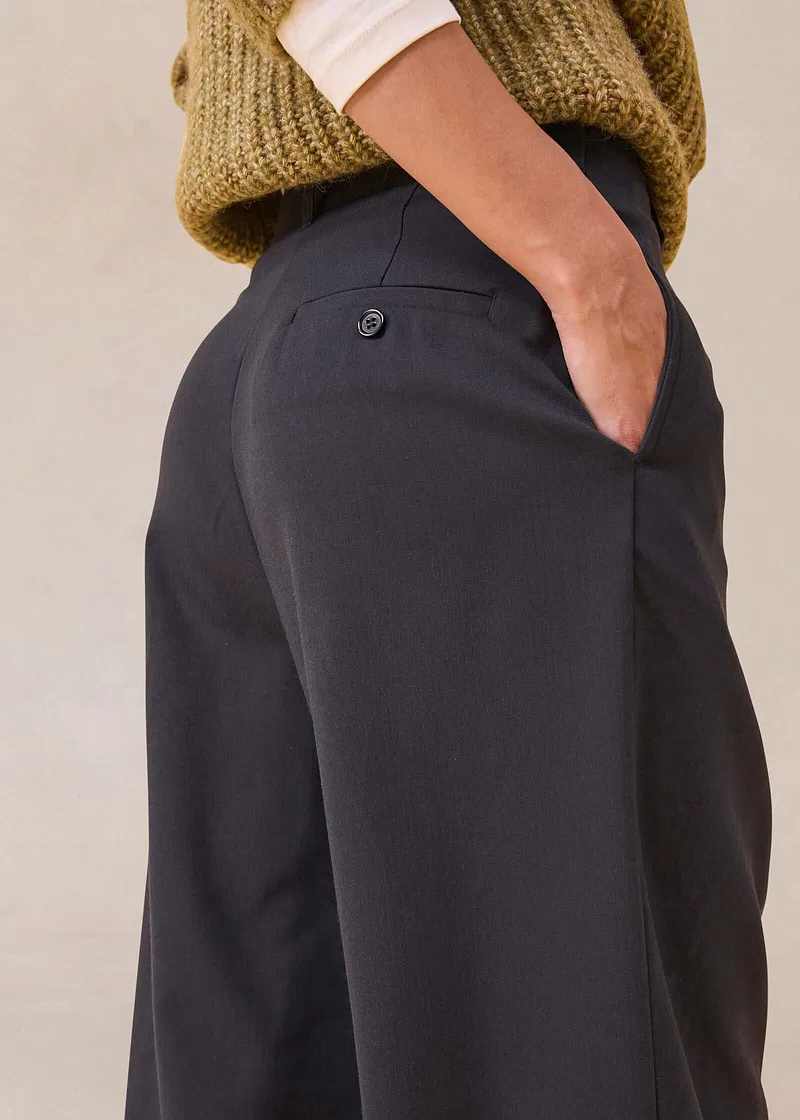 Pantalon noir avec poches, associé à un pull en maille chaud.