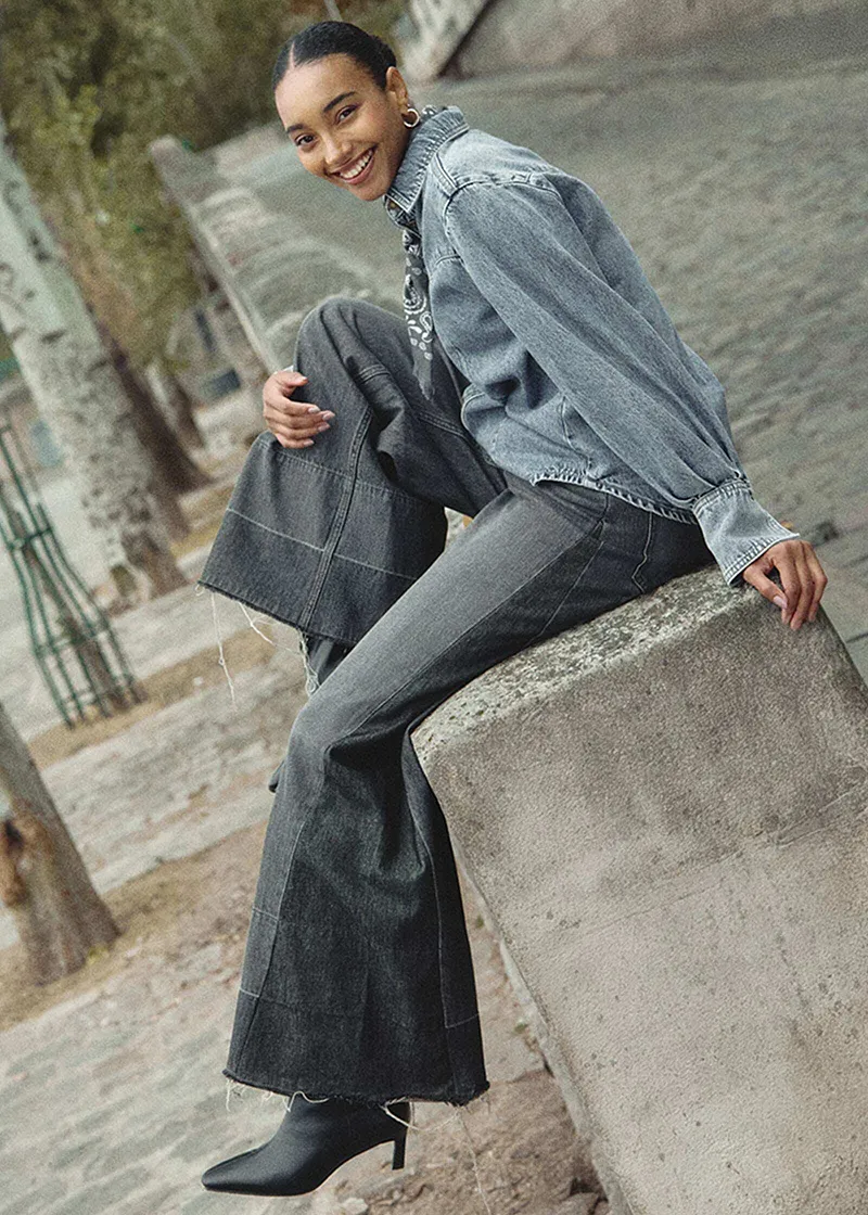 Tenue composée d'une veste en jean et d'un jean large gris.