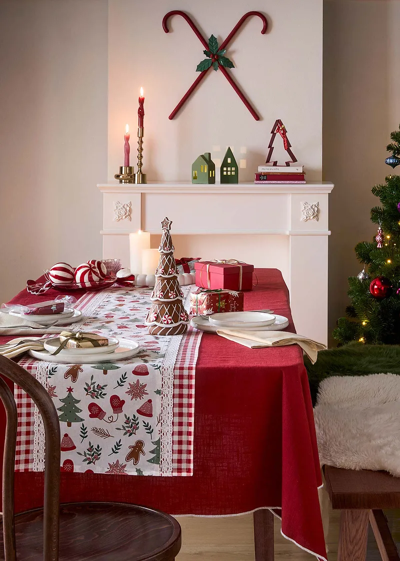 Festliche Tischdecke mit weihnachtlichem Muster schmückt den gedeckten Tisch.