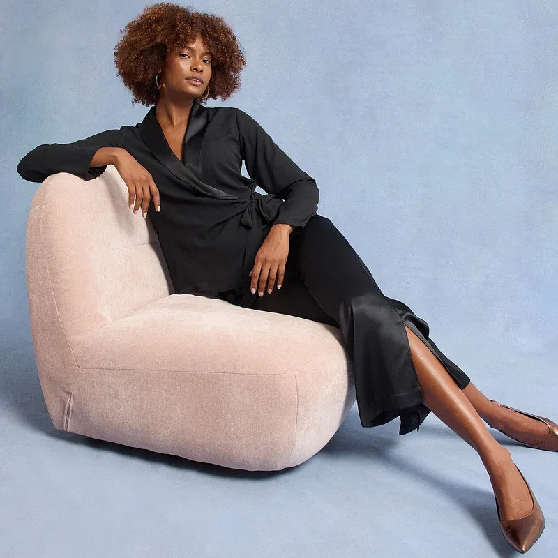 Schwarzes Kleid mit schwarzen Satinhosen.