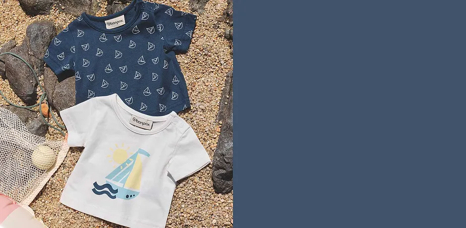 Deux T-shirts d'été pour enfant : un avec des motifs voiliers, l'autre avec un motif plage.