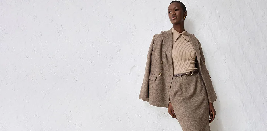 Blazer de couleur beige avec un pull en maille et une jupe assortie.