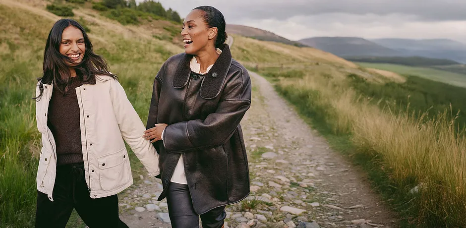 Manteau marron élégant avec grand col associé à un haut clair et un pantalon foncé.