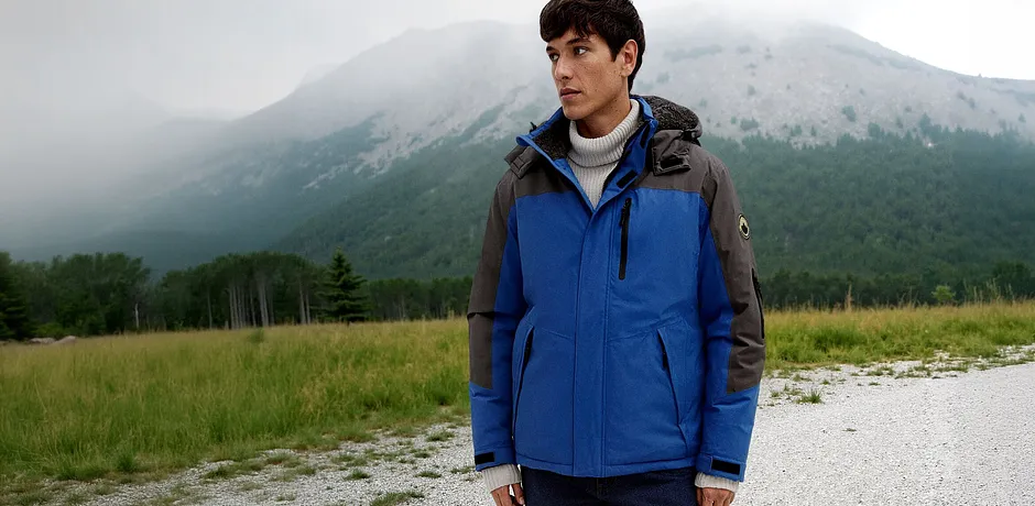 Veste de plein air bleue à capuche pour rester à l'abri du vent et du froid. 