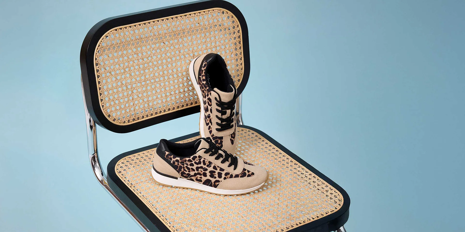 Stylische Leoparden-Sneaker auf geflochtenem Untergrund.