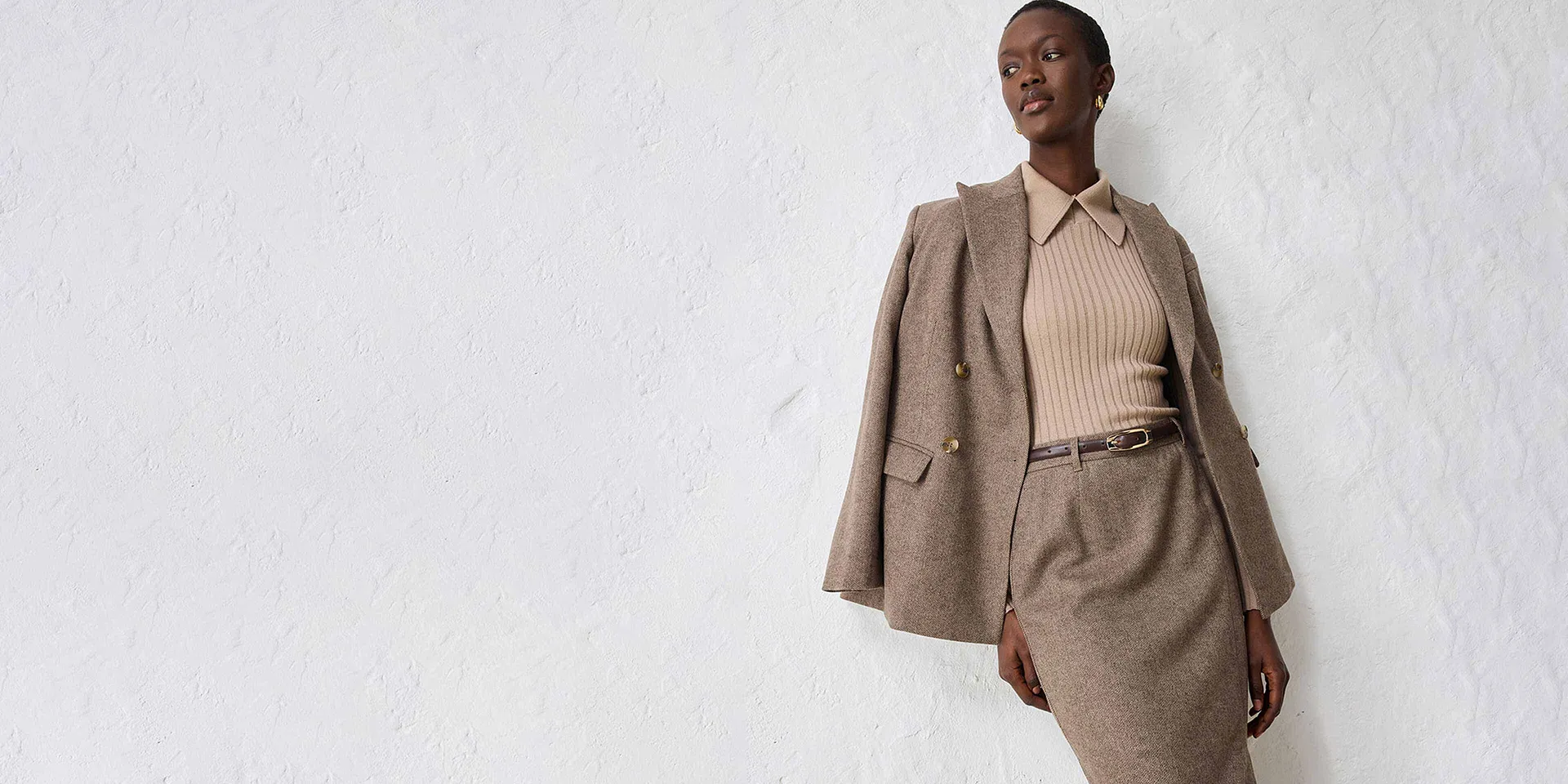 Beigefarbener Blazer mit passendem Strickpullover und Rock.