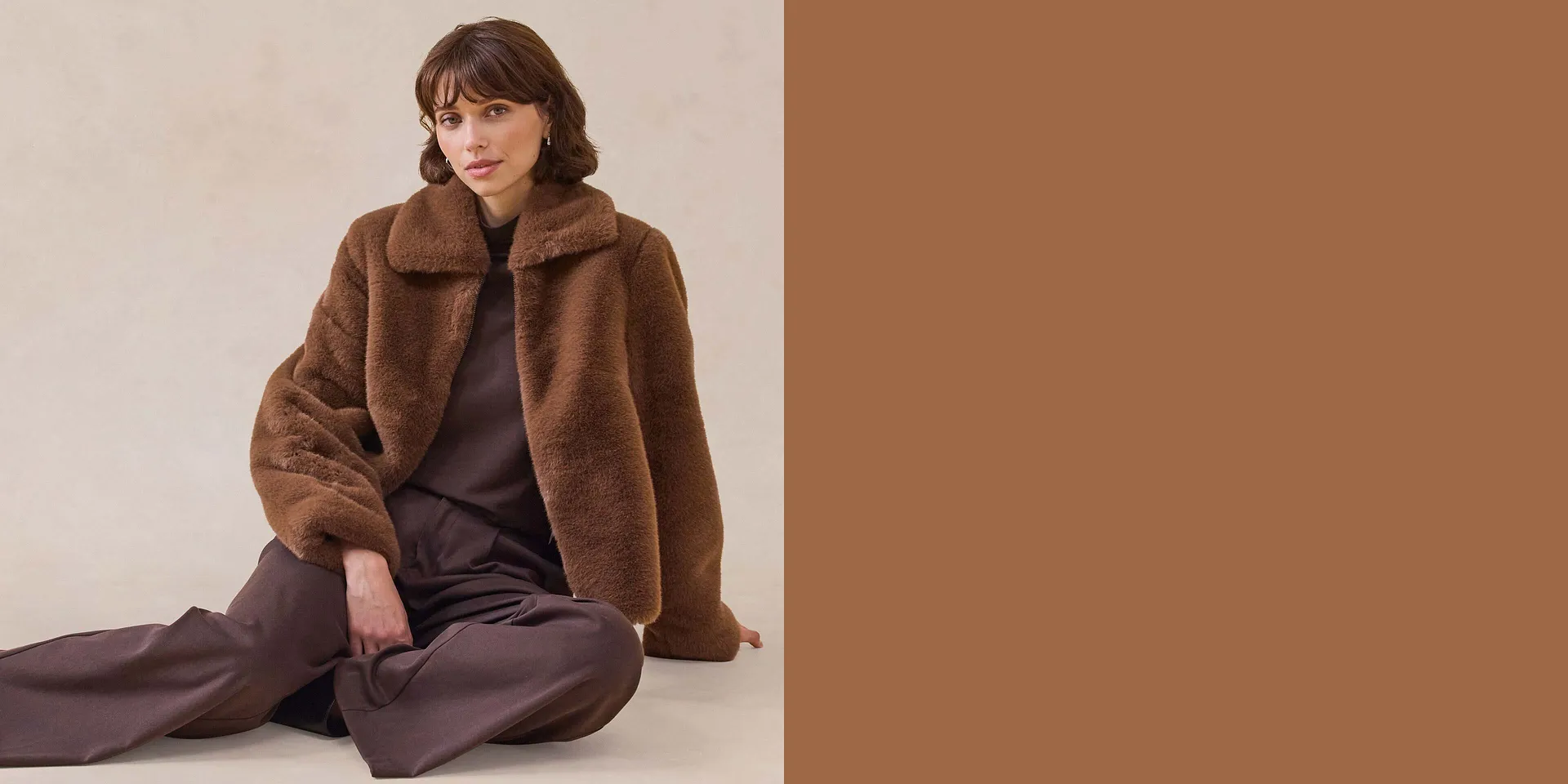 Manteau marron en peluche ultra-douillet avec grand col, porté sur un haut foncé et un pantalon large.