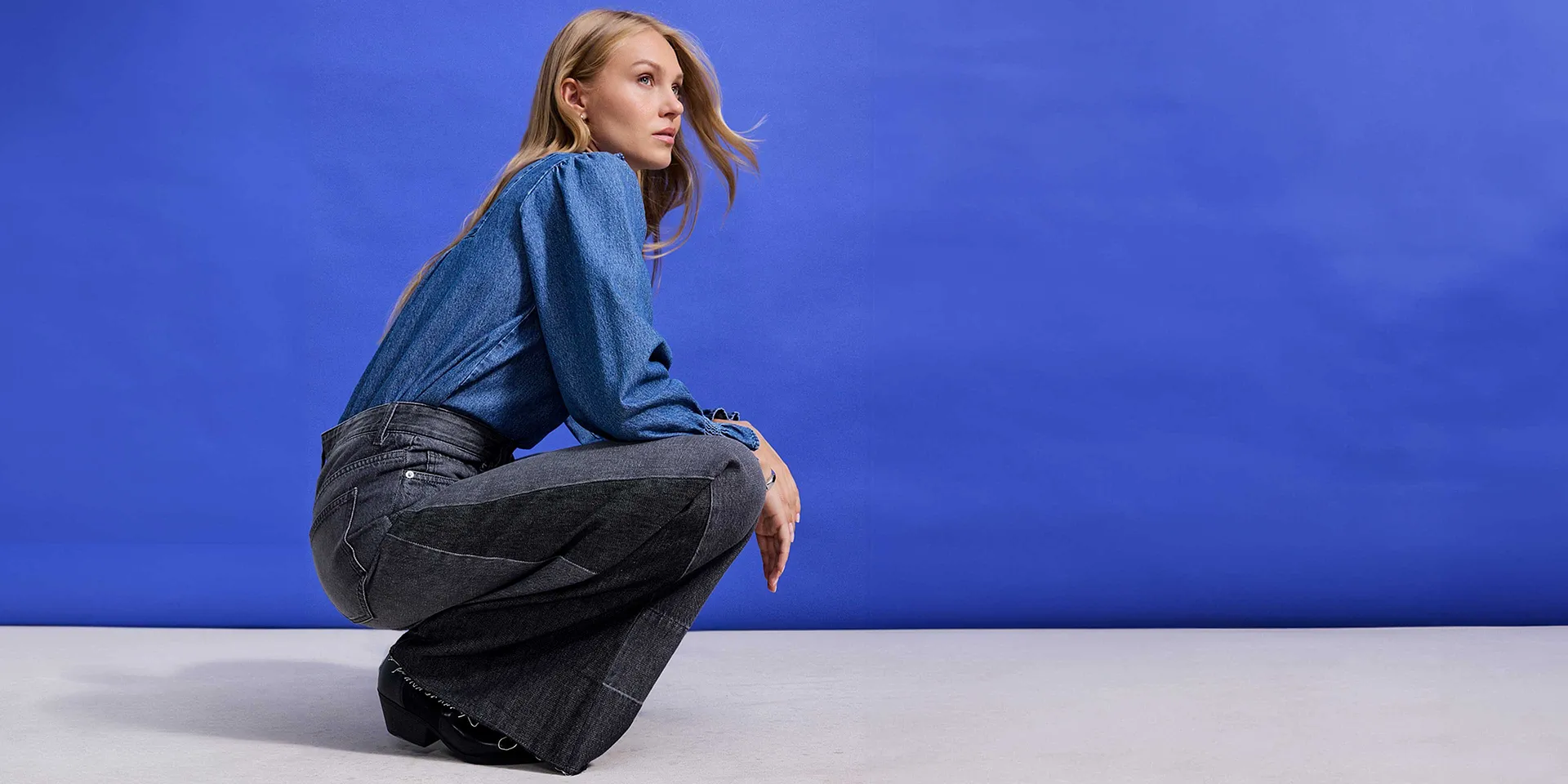 Chemise bleue à ruchés et jean large.