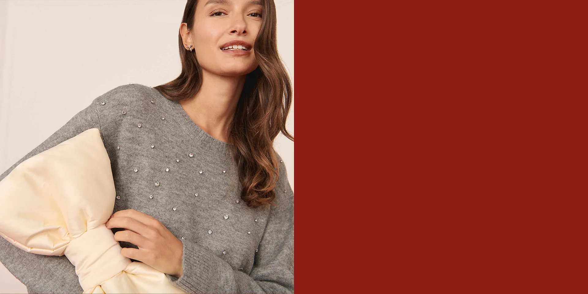 Eleganter grauer Pullover mit Perlenverzierung.