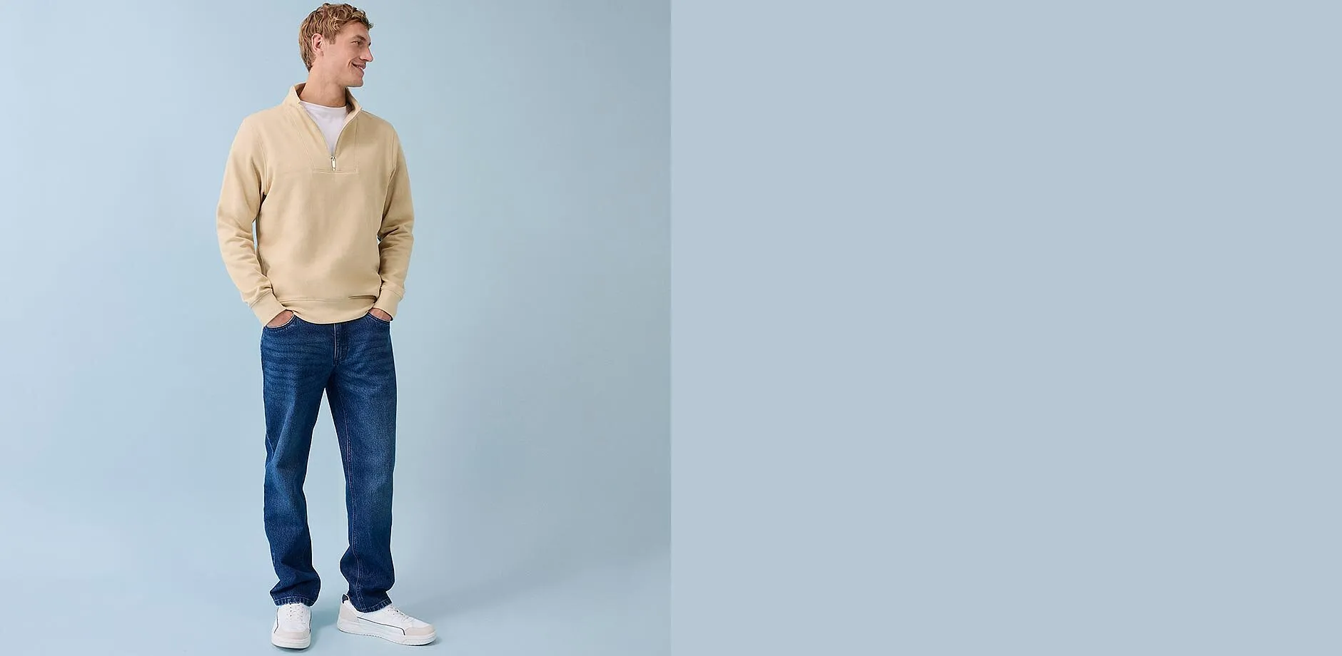Beiger Pullover mit Rei&szlig;verschluss, blaue Jeans und wei&szlig;e Sneakers - l&auml;ssiger Alltagslook f&uuml;r M&auml;nner.