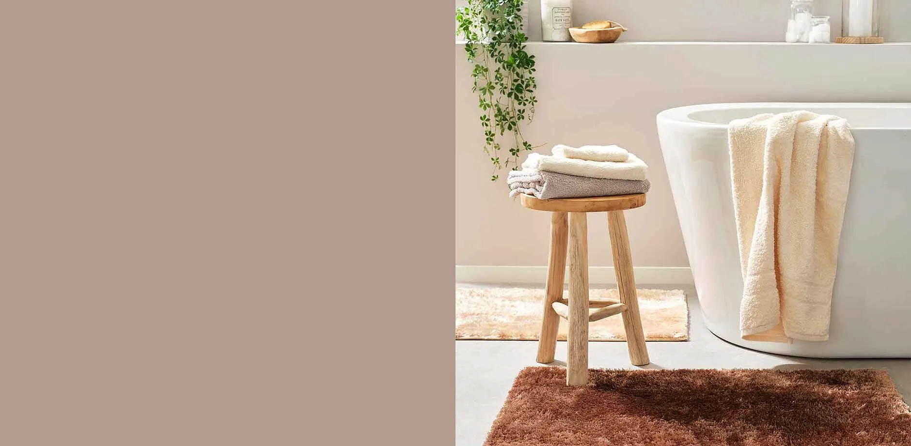 Une commode pratique avec des tiroirs à côté de la baignoire, sur laquelle est posée une serviette bleue.