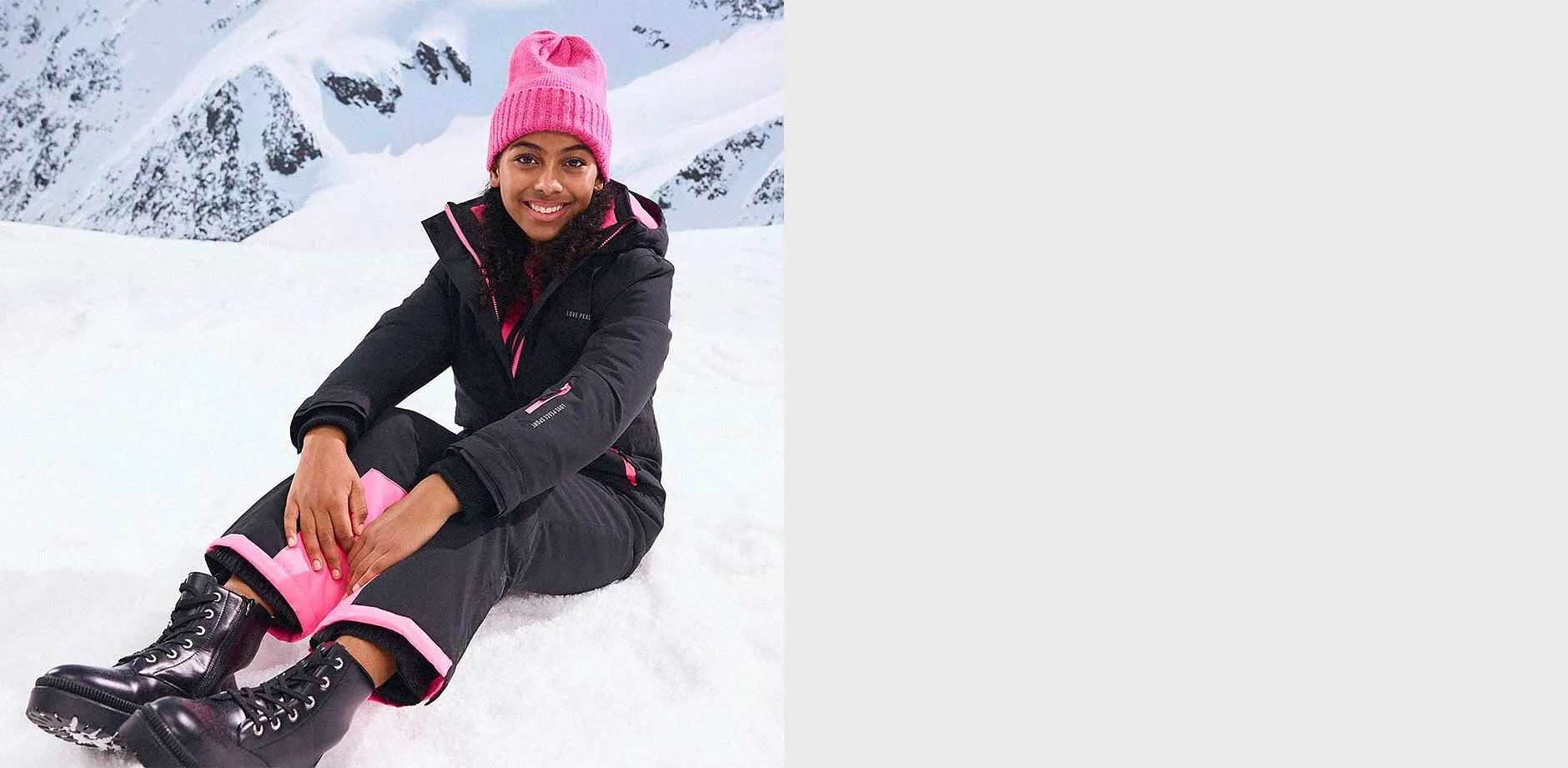 Veste d'hiver noire et pantalon assorti, bonnet rose.