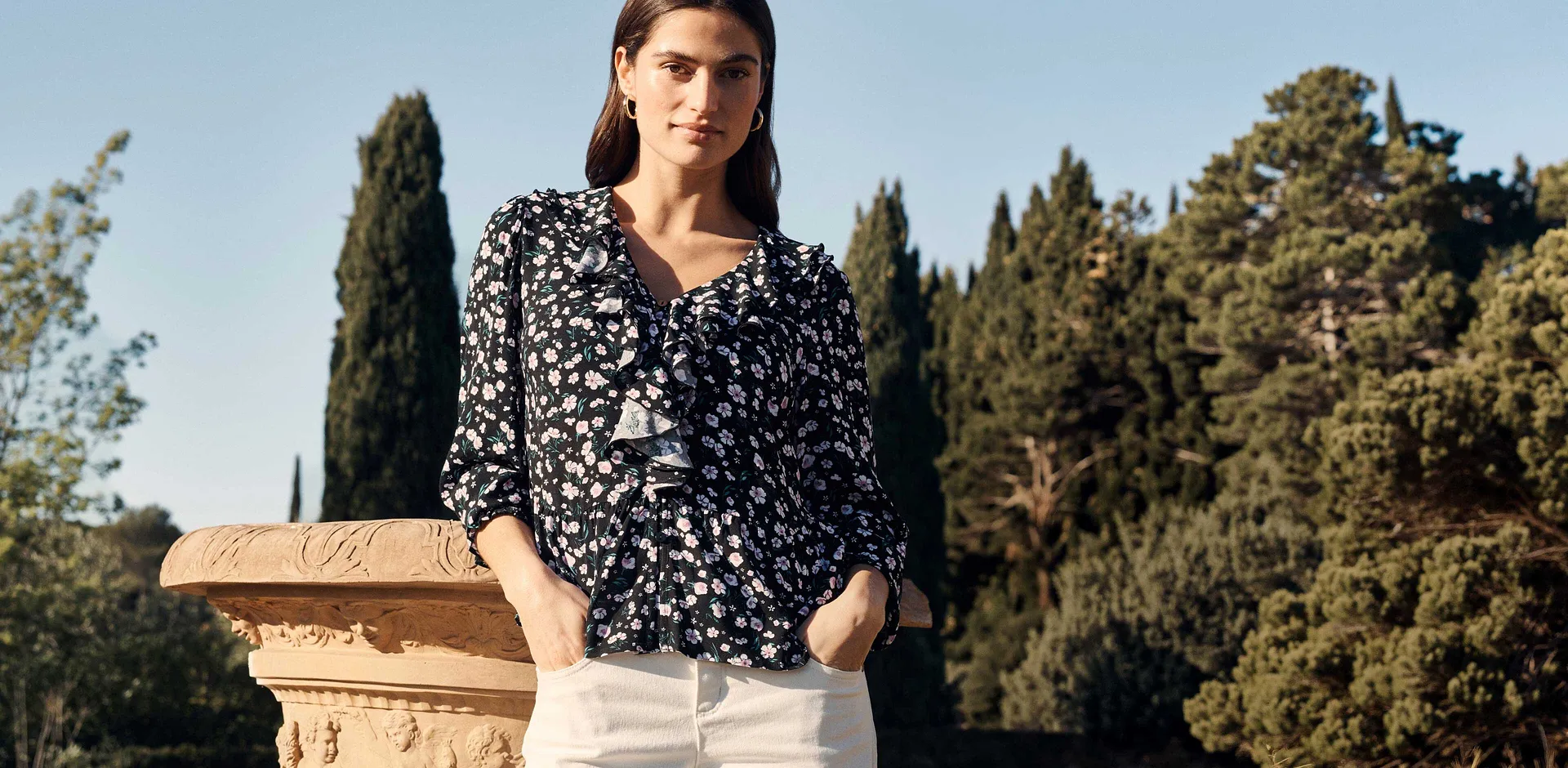 Kombination aus gemusterter Bluse und wei&szlig;er Hose.