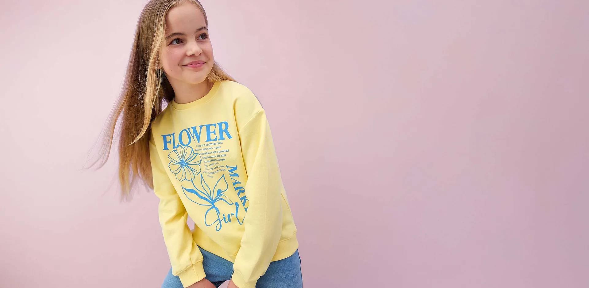 Gelbes Langarmshirt mit Blumenmuster und Text.