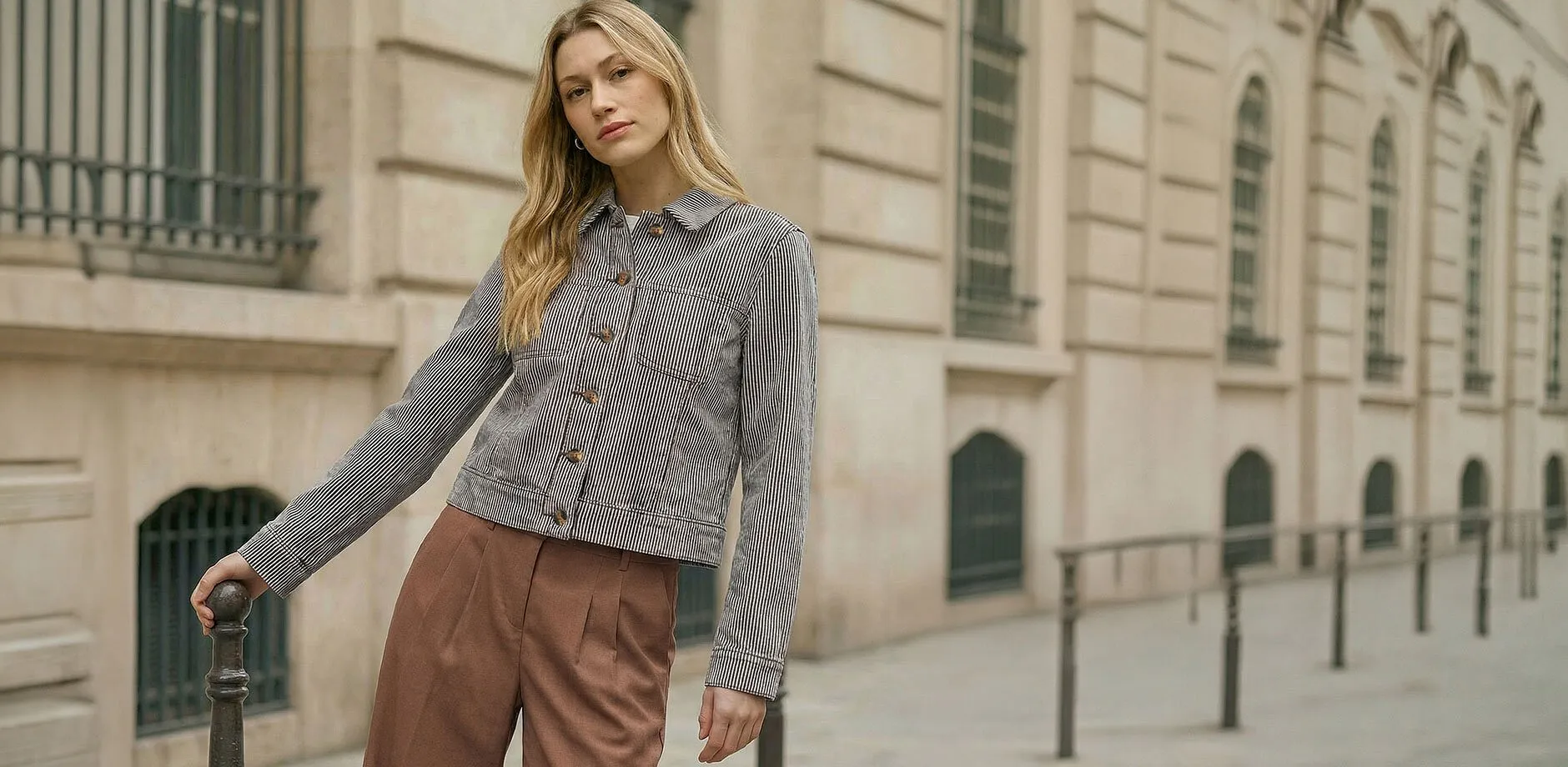 Veste de mi-saison &agrave; imprim&eacute; ray&eacute; noir associ&eacute;e &agrave; un pantalon marron.