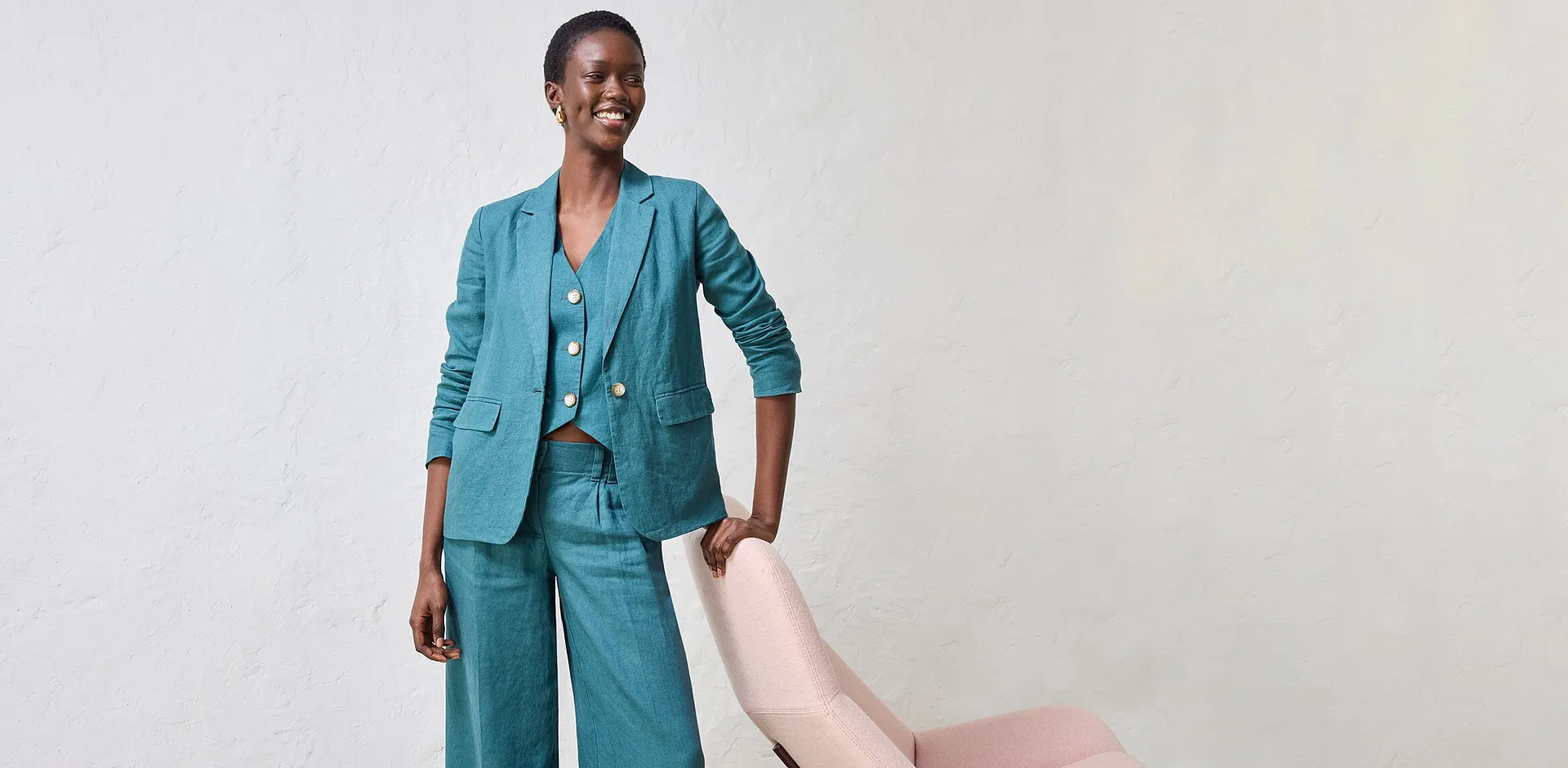 Ensemble tailleur pantalon turquoise avec pantalon large, gilet sans manches et veste.