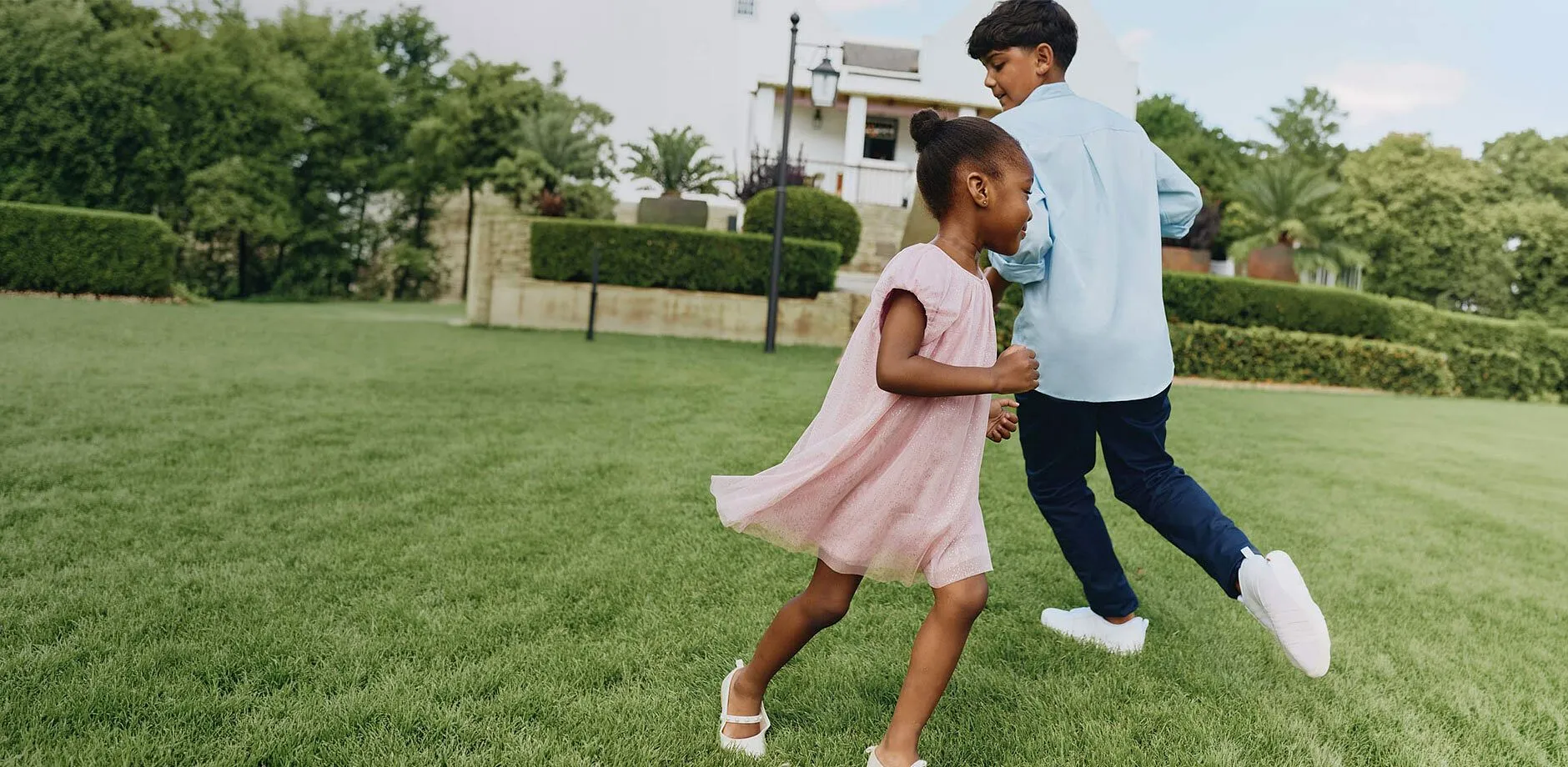 Hellblaues Hemd, blaue Hose, rosa Kleid und wei&szlig;e Schuhe f&uuml;r die Feier.