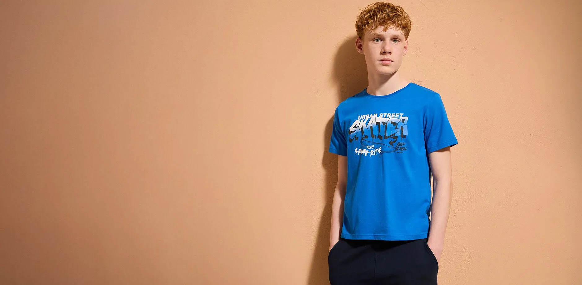 L&auml;ssiger Look: Blaues T-Shirt, helle Jeans und bequeme Sneakers. Stilvolle Kombination f&uuml;r den Alltag.