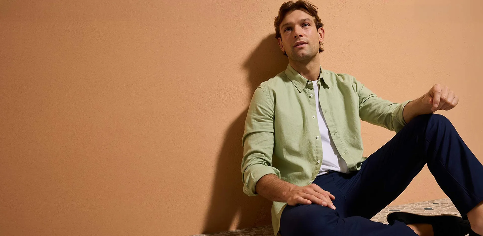 Chemise vert pastel, pantalon bleu fonc&eacute; et chaussures d&eacute;contract&eacute;es.