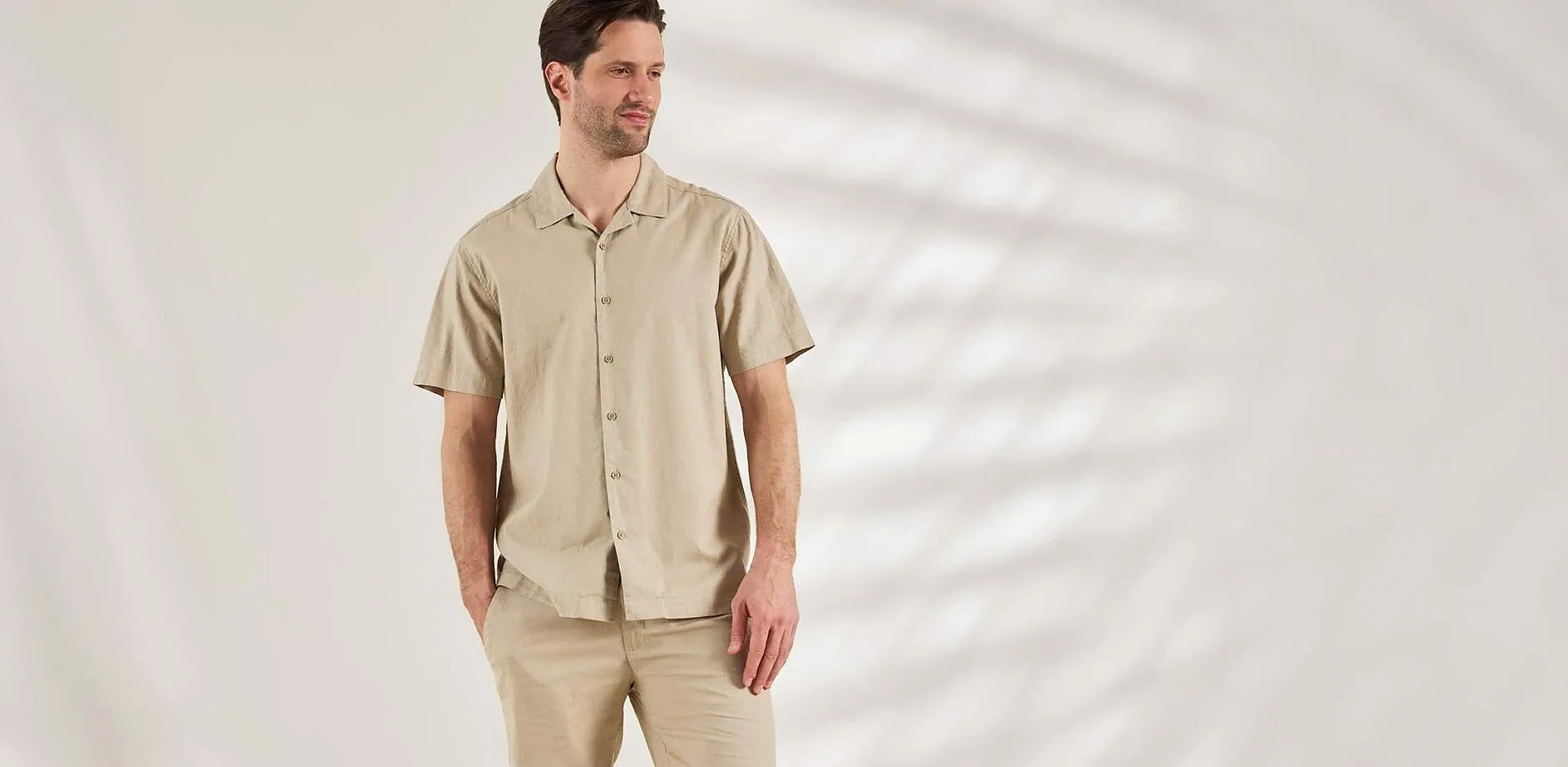 Tenue compos&eacute;e d'une chemise beige &agrave; manches courtes et d'un pantalon assorti pour un look d&eacute;contract&eacute;.