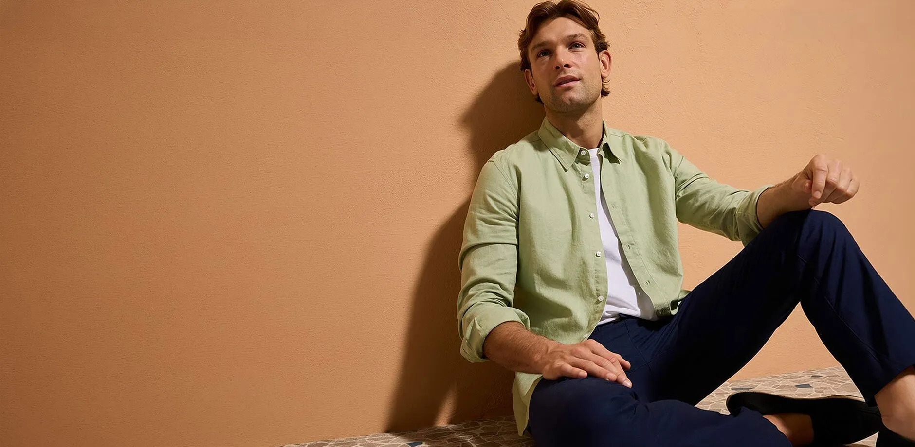 Chemise vert pastel sur un T-shirt blanc, associ&eacute;e &agrave; un pantalon de couleur fonc&eacute;e.