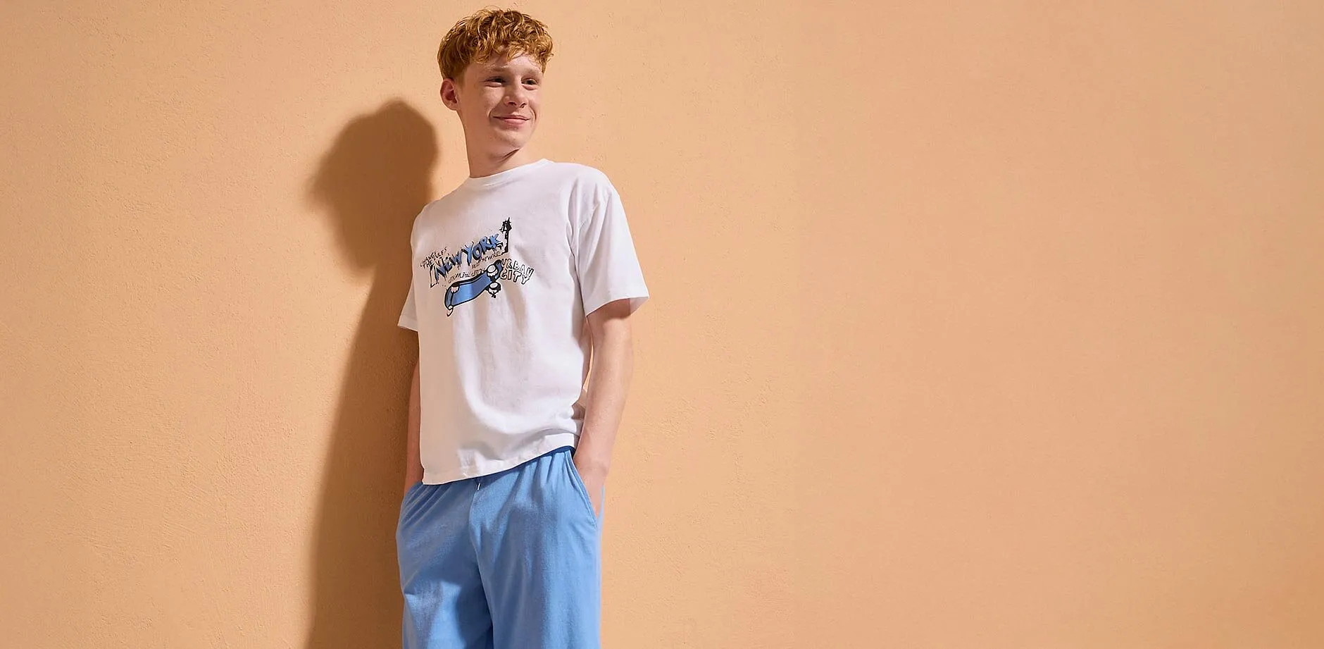 Ein Junge tr&auml;gt ein wei&szlig;es T-Shirt mit Print.