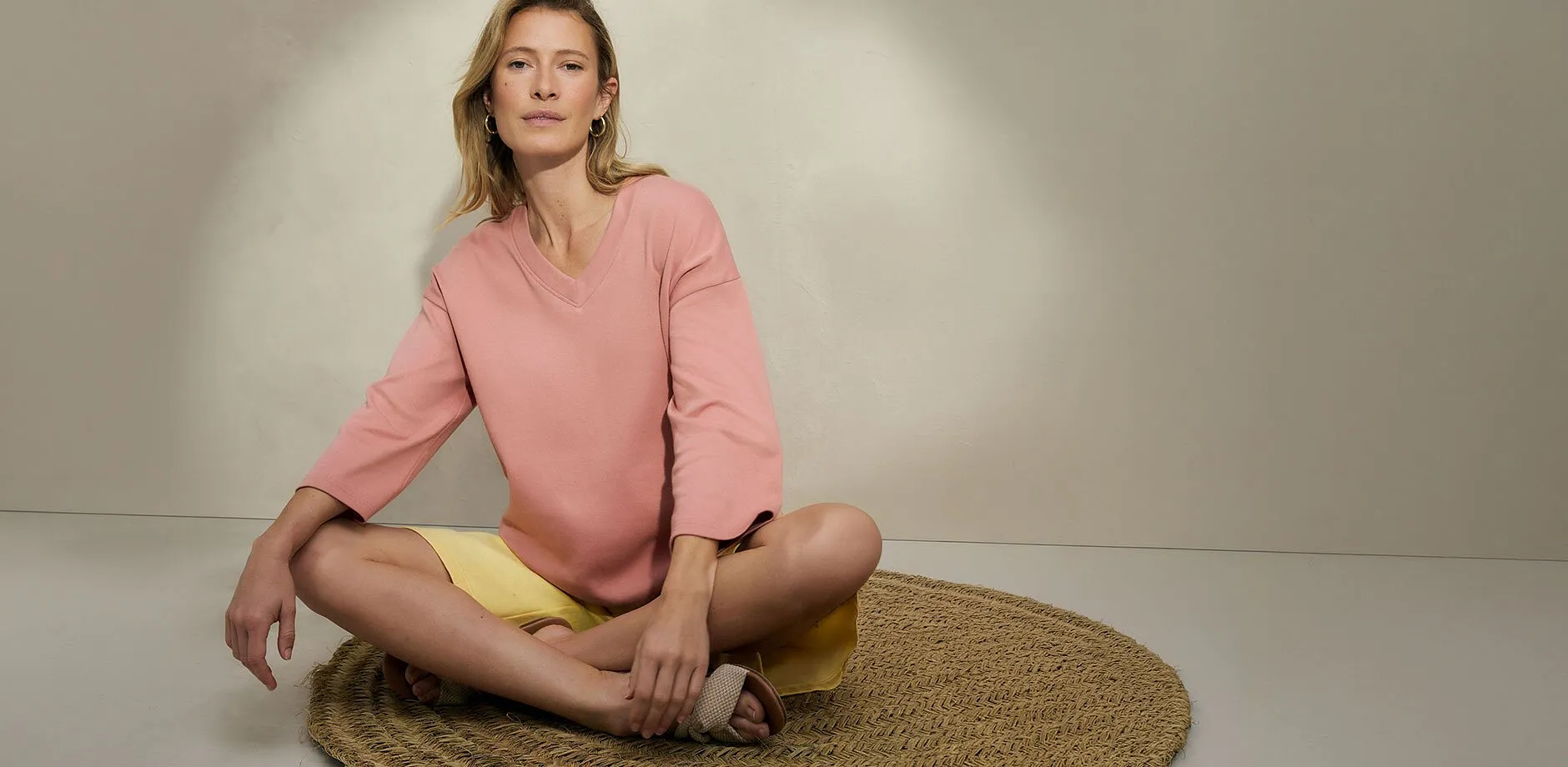 Frau tr&auml;gt rosa Bluse mit gelber Shorts.