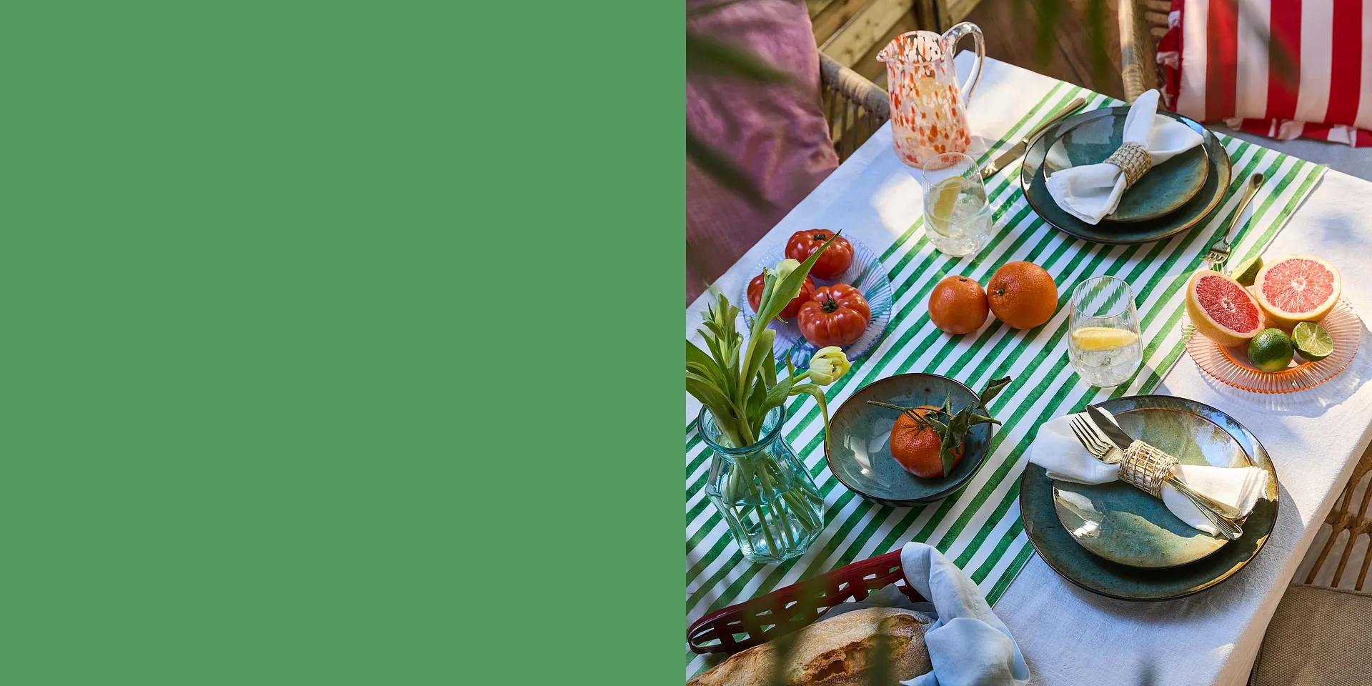 Ein gestreiftes Tischtuch schm&uuml;ckt den sommerlichen Tisch mit buntem Geschirr und frischem Obst.