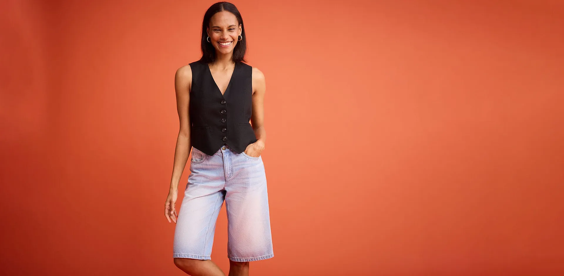 Schwarze Weste mit Kn&ouml;pfen kombiniert mit hellblauen Jeans-Shorts.