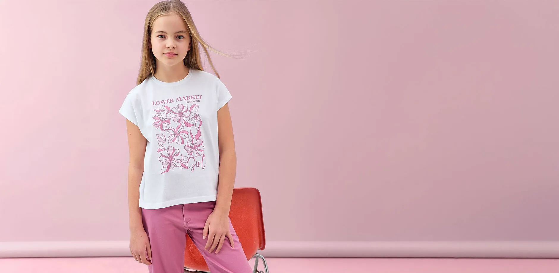 T-shirt blanc avec imprim&eacute; fleurs roses et pantalon rose. 