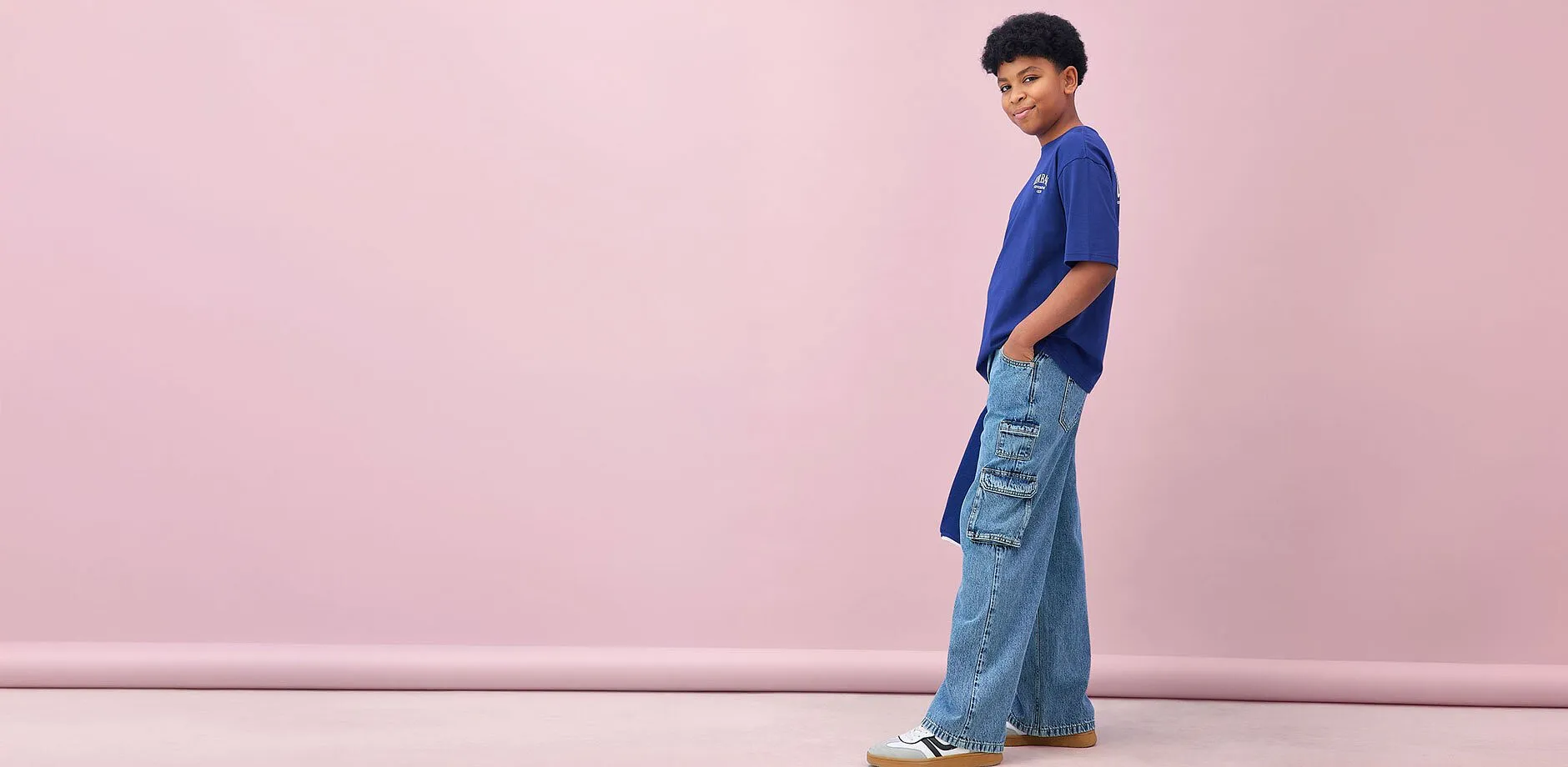 Le gar&ccedil;on porte un T-shirt bleu et un jean cargo large.