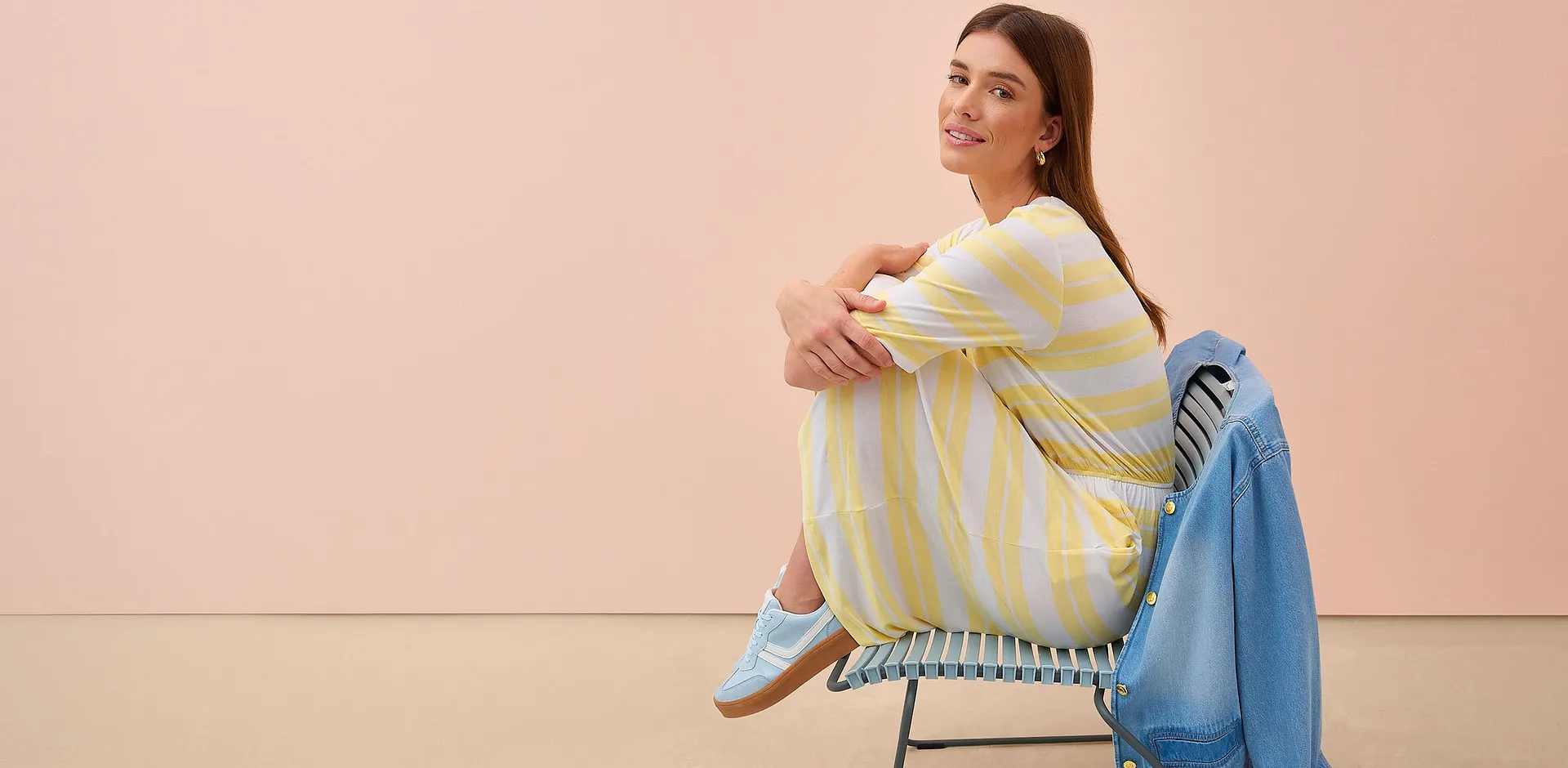 Femme v&ecirc;tue d'une robe ray&eacute;e jaune et blanc.