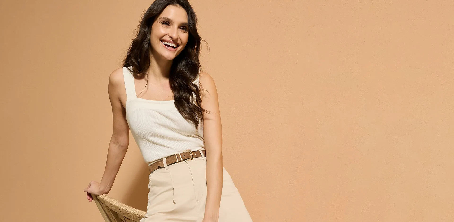 Top blanc et pantalon beige dans un style minimaliste.