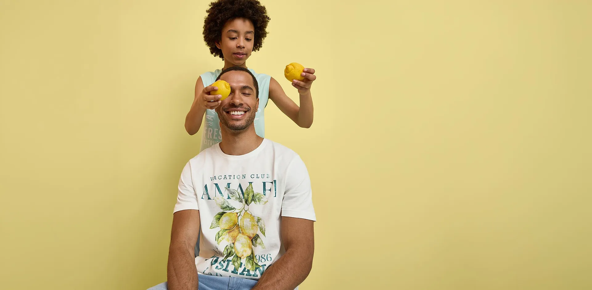 Un homme et un gar&ccedil;on v&ecirc;tus de T-shirts color&eacute;s &agrave; imprim&eacute; citrons.