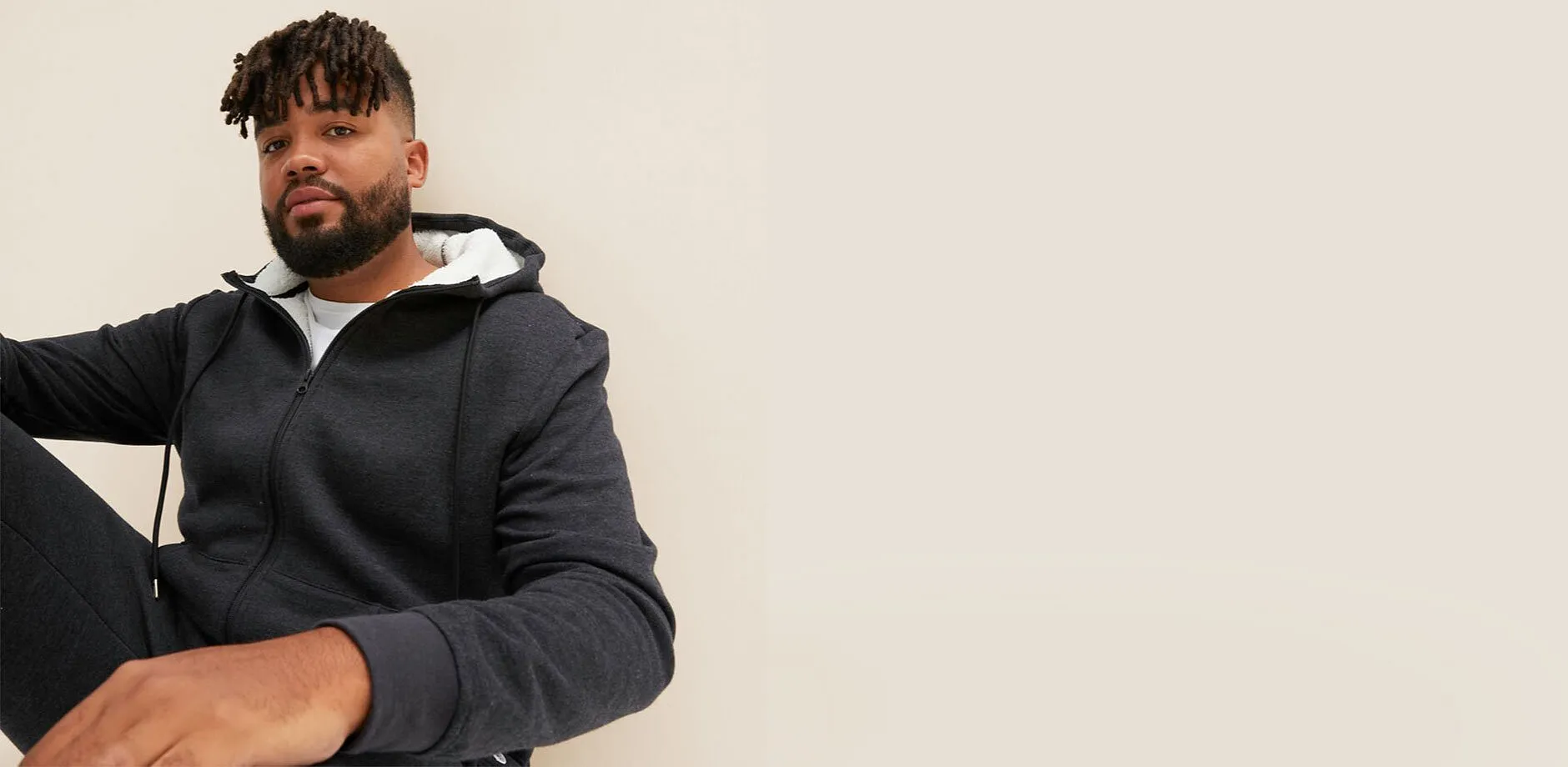 Eine dunkelgraue Kapuzenjacke mit wei&szlig;em Futter.