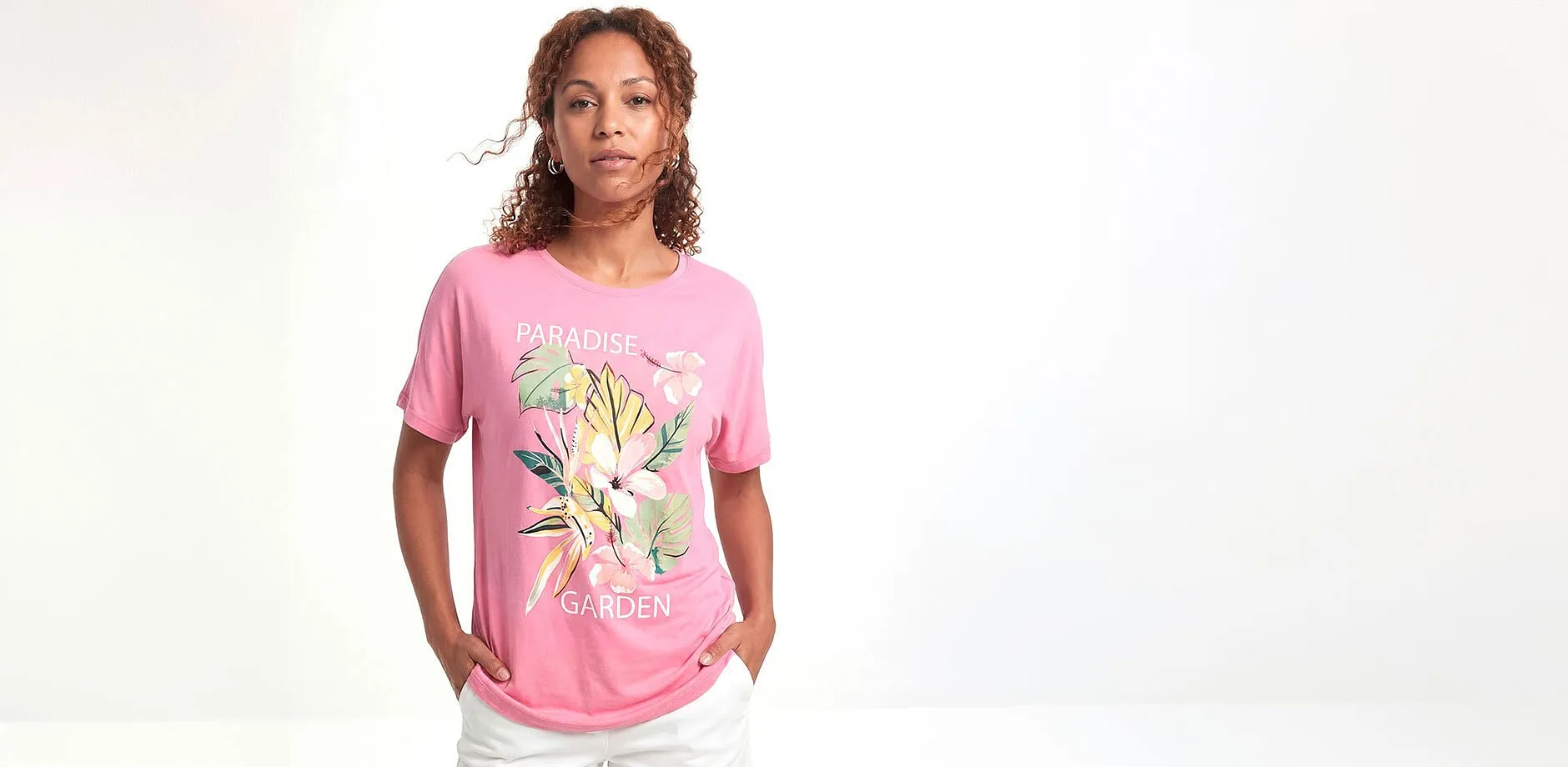 T-shirt rose &agrave; motif floral et pantalon blanc.