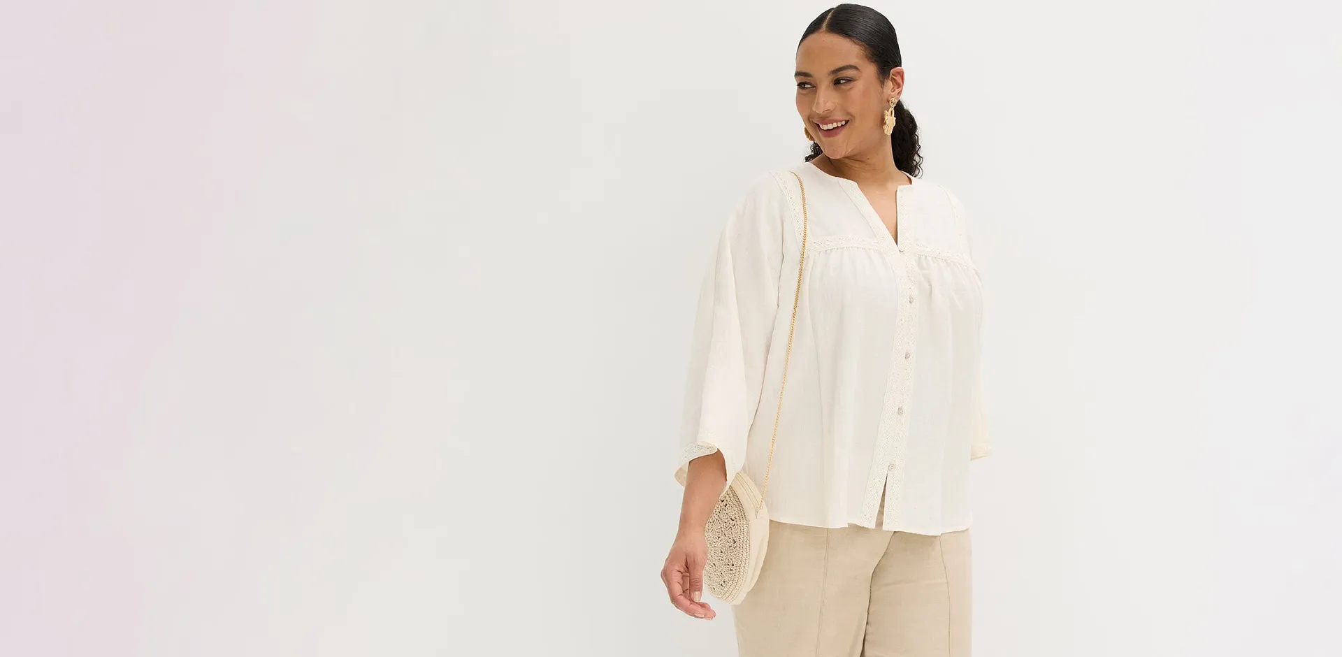 Blouse blanche de coupe large avec petits boutons.